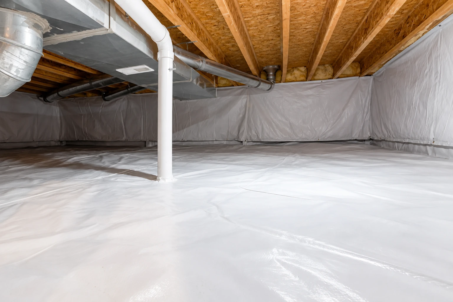 Crawl space with white vapor barrier covering the floor and walls beneath exposed joists and metal ductwork.
